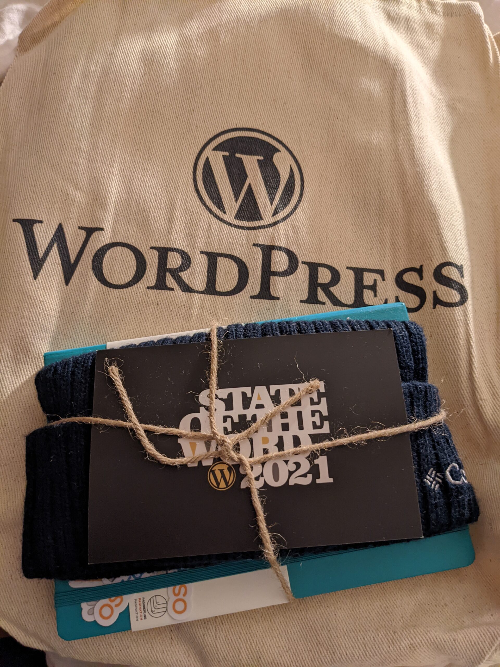 A tote bag and hat with WordPress logos on them